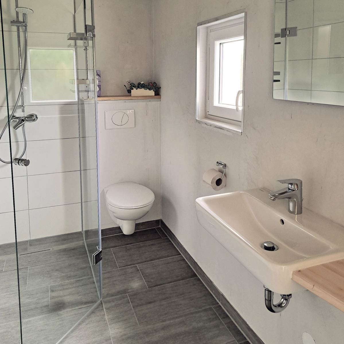 Schickes Bad mit Handtuchtrockner und großzügiger Dusche